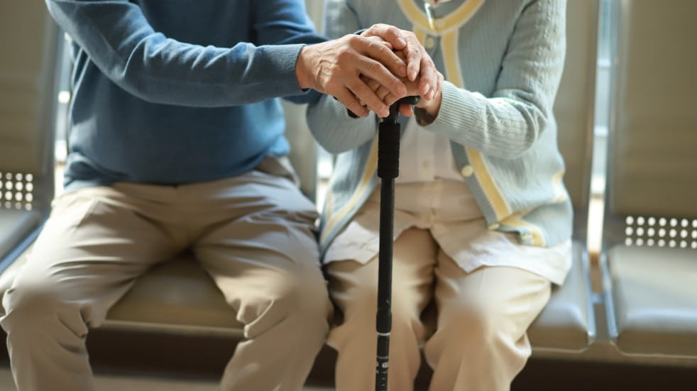 older couple holding walking stick